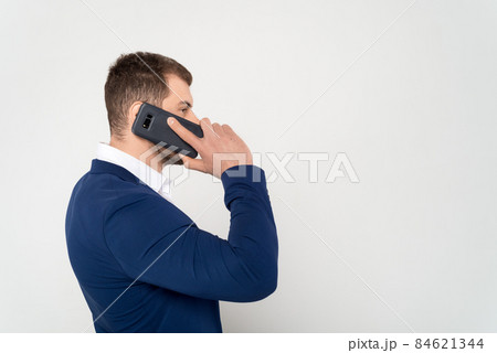 Close up of young business man in suit speaks on cell phone on white background 84621344