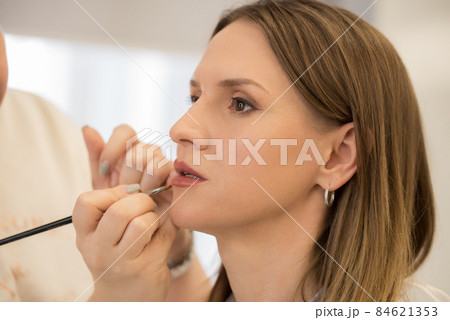 Makeup Artist applies lipstick to a beautiful woman 84621353