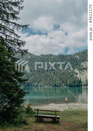 Relax. Rest near lake. Wooden bench overlooking the lake and mountains. Beautiful mystical lake. Black Lake, Durmitor National Park. Montenegro 84622270