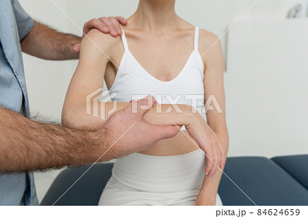 Osteopathic arm or shoulder massage. Elbow pain relief. Chiropractic treatment. Doctor doing shoulder blade therapy. Stretching and exercise, doing the rehabilitation therapy pain in clinic. 84624659