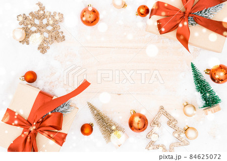 Christmas frame. Winter wooden decoration background. Xmas board with old rustic wall, white frozen snow, golden balls and gift box. Top view with copy space. Christmas frame. Winter wooden decoration background. Xmas board with old rustic wall, white frozen snow, golden balls and gift box. Top view with copy space. 84625072