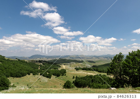 Mountain landscape. Mountains with green grass and bright blue sky. Idyllic panorama. Tourism concept. Hiking. Vacation in Europe. Relax in the open air and the spirit of adventure. Ecology of nature 84626313