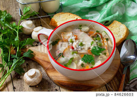 Traditional rustic thick german pea soup with smoked bacon, mushrooms and cereals on wooden table. Hot dinner or lunch. Traditional rustic thick german pea soup with smoked bacon, mushrooms and cereals on wooden table. Hot dinner or lunch. 84626603