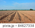Lines of soil made by tractors has blue sky and mountain background ,agriculture in Thailand 84627338