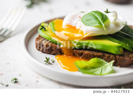 Toasted bread with poached egg Toasted bread with poached egg 84627933