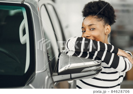 Young african american woman in car salon Young african american woman in car salon 84628706