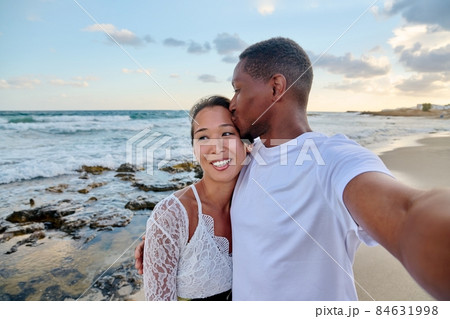 Happy couple in love kissing taking selfie together on smartphone, on beach 84631998
