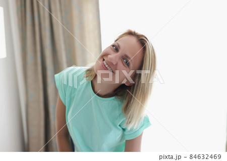 Happy smiling blonde young woman in apartment posing on curtain Happy smiling blonde young woman in apartment posing on curtain 84632469