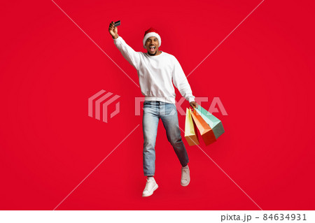 African american man Santa Claus holding purchases and credit card 84634931