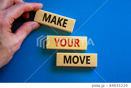 Make your move symbol. Wooden blocks with words 'Make your move'. Beautiful blue background, businessman hand. Business, make your move concept, copy space. Make your move symbol. Wooden blocks with words 'Make your move'. Beautiful blue background, businessman hand. Business, make your move concept, copy space. 84635220