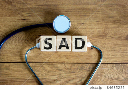 SAD, social anxiety disorder symbol. Concept words 'SAD, social anxiety disorder' on cubes on a beautiful wood background. Medical, psychological and SAD, social anxiety disorder concept. Copy space. SAD, social anxiety disorder symbol. Concept words 'SAD, social anxiety disorder' on cubes on a beautiful wood background. Medical, psychological and SAD, social anxiety disorder concept. Copy space. 84635225