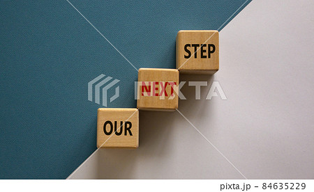 Conceptual image of motivation. Wooden cubes with words 'our next step'. Beautiful white and blue background, copy space. Business concept. Conceptual image of motivation. Wooden cubes with words 'our next step'. Beautiful white and blue background, copy space. Business concept. 84635229
