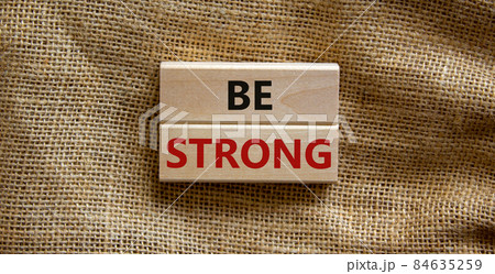 Be strong symbol. Wooden blocks with words 'be strong'. Beautiful canvas background. Copy space. Motivational, business and be strong concept. Copy space. 84635259