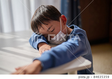 風邪をひいてぐったりする小学生の男の子 84635359