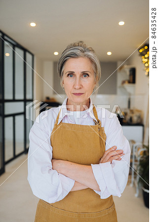 Portrait of strict granny standing in displeased pose staring angry at camera 84635428