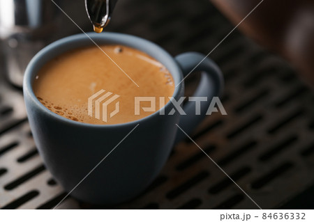 Closeup espresso last drop with single spout portafilter in blue cup Closeup espresso last drop with single spout portafilter in blue cup 84636332