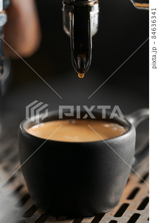 Closeup espresso last drop with single spout portafilter in black cup Closeup espresso last drop with single spout portafilter in black cup 84636341