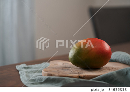 Whole ripe red mango on olive wood board Whole ripe red mango on olive wood board 84636358