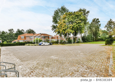 Cozy street with beautifully laid paving stones and lots of greenery Cozy street with beautifully laid paving stones and lots of greenery 84638384
