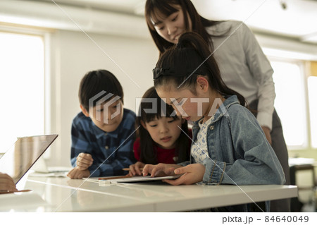 ICT教育　タブレットを見る小学生と教師 84640049