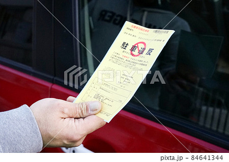 駐車違反のステッカーを手に持つ男性 84641344
