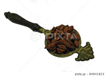 Red goji Berries (dried) in old brass spoon isolated on white background. Red goji Berries (dried) in old brass spoon isolated on white background. 84642823