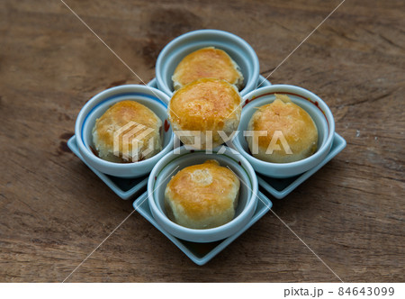 A traditional asian pastry or Tao Sor on rustic wooden table. Chinese sweet pastry filled with mung bean paste, taro, and salted egg. A traditional asian pastry or Tao Sor on rustic wooden table. Chinese sweet pastry filled with mung bean paste, taro, and salted egg. 84643099