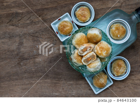 A traditional asian pastry or Tao Sor in vintage green glass bowl. Chinese sweet pastry filled with mung bean paste, taro, and salted egg. 84643100