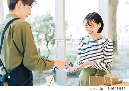 スマホ決済をする若い女性 スマホ決済をする若い女性 84643985