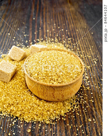 Sugar brown in bowl on dark board Sugar brown in bowl on dark board 84644107