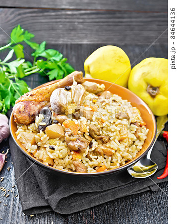 Pilaf with duck and quince in plate on napkin Pilaf with duck and quince in plate on napkin 84644136