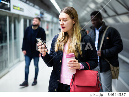 Woman using phone at underground station 84644587