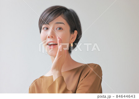 口の横に手を当てて話す女性1 84644643