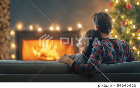 couple relaxing near Christmas tree 84645419