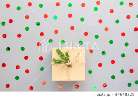 New Year background or Christmas card. Beige gift box, fir branch and confetti. Top view, copy space. 84648229