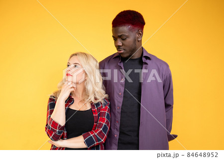 People disagreement. Argue compromise. Misunderstanding problem. Mixed race friends after conflict offended Caucasian woman confused African man isolated on yellow background. 84648952