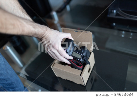 Adult man small business owner packing order box package shipping to customer. Entrepreneur packaging box for delivery at home Adult man small business owner packing order box package shipping to customer. Entrepreneur packaging box for delivery at home 84653034