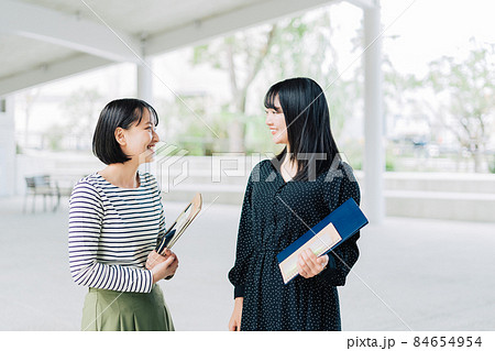 キャンパスで談笑する女子大学生 84654954