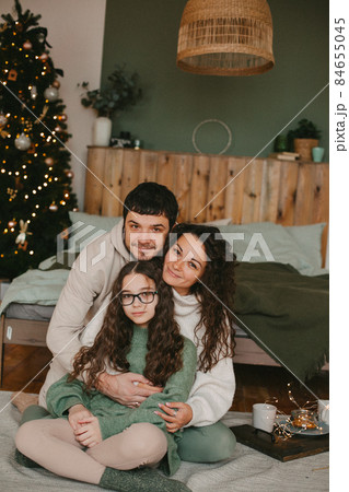 young family mom dad and teenage daughter on background of christmas interior 84655045