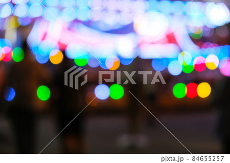 Defocused bright lights flash at a fun carnival at night. Amusement Park Bokeh Lights at Night. Nightlife entertainment Defocused bright lights flash at a fun carnival at night. Amusement Park Bokeh Lights at Night. Nightlife entertainment 84655257