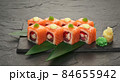 sushi rolls with tuna salmon eel unagi and avocado on a black stone plate. 84655942