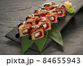 sushi rolls with tuna salmon eel unagi and avocado on a black stone plate. 84655943