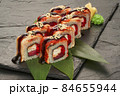 sushi rolls with tuna salmon eel unagi and avocado on a black stone plate. 84655944
