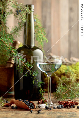 Gin, anise, and juniper berries on a wooden table. Gin, anise, and juniper berries on a wooden table. 84656500