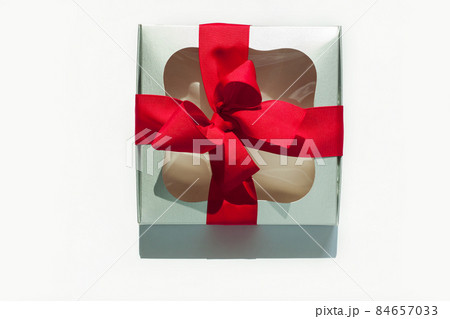 Silver gift box with red ribbon bow isolated on white background. Copy space, flatlay, top view. 84657033