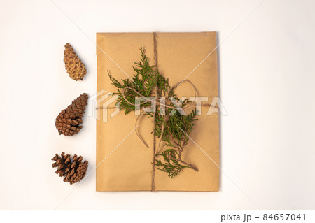 Eco gift box wrapping in kraft paper on white background isolated.Composition present decorated Christmas tree branches. Eco gift box wrapping in kraft paper on white background isolated.Composition present decorated Christmas tree branches. 84657041