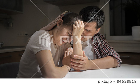 Young man consoling and comforting his upset crying woman suffering from depression and stress 84658918