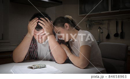 Young loving wife comforting and consoling her husband having financial problems and difficulties 84658963