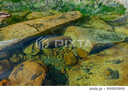 Large granite blocks and many small rocks underwater 84660966