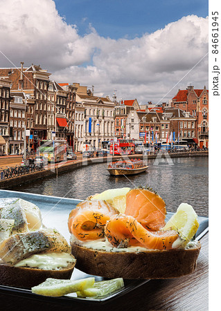 Amsterdam city with fishplate (salomon and codfish sandwiches) against tourboat on canal in Netherlands Amsterdam city with fishplate (salomon and codfish sandwiches) against tourboat on canal in Netherlands 84661945